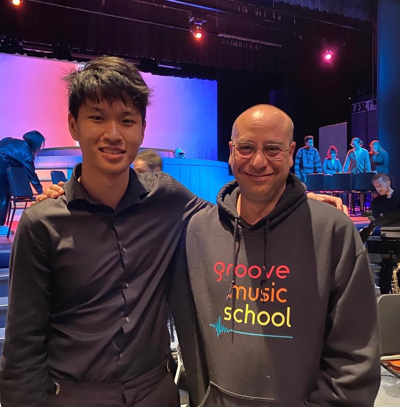 Two instructors in Groove Music School hoodie backstage