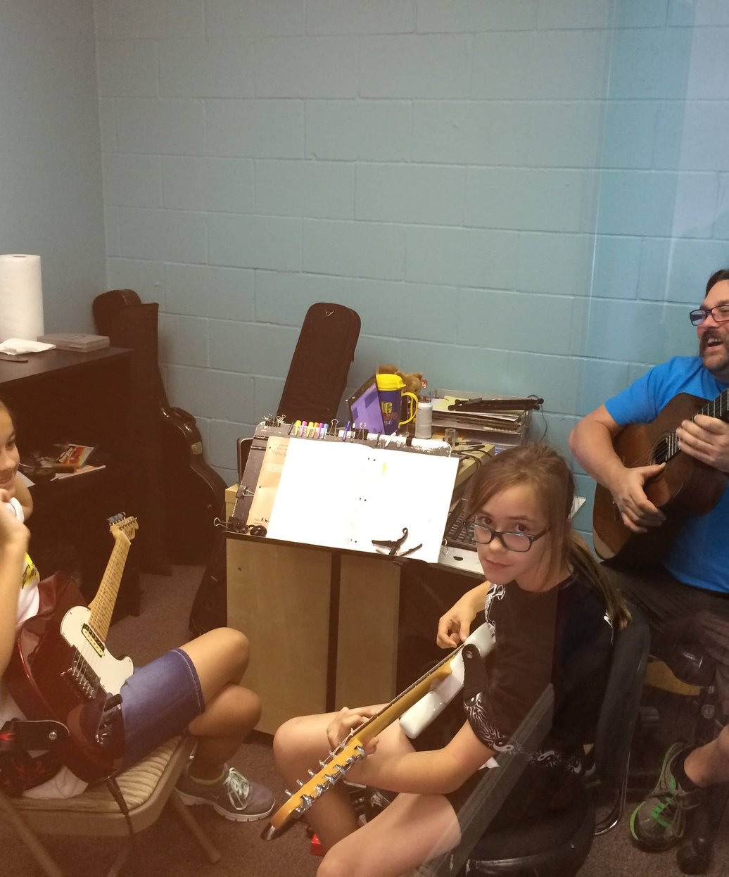 Students learning flute and guitar in music lesson